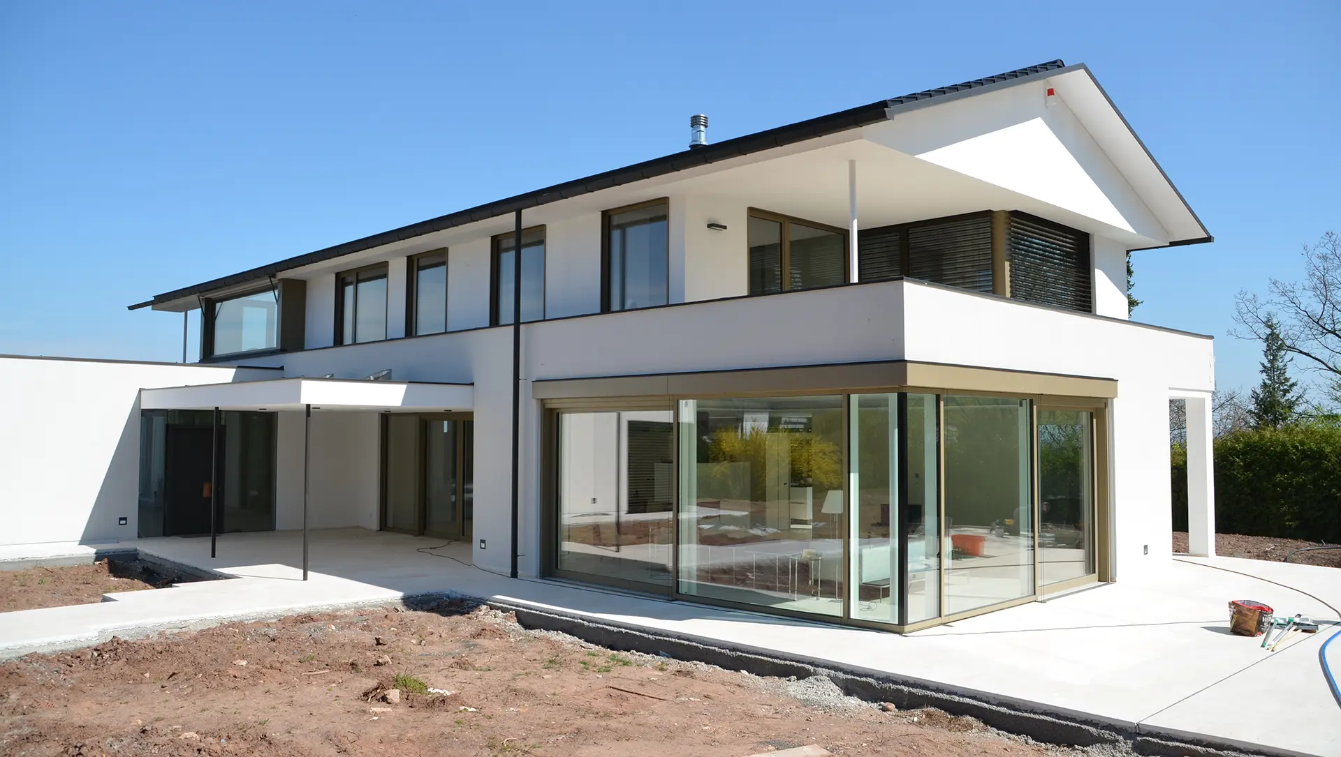 Modernes Neubaugebäude mit großen Holzaluminium Schiebetüren der Leopold Fenstermanufaktur