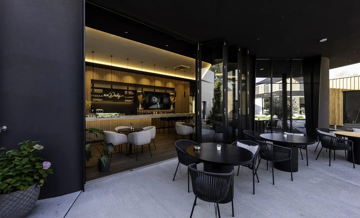 Lokal, bei dem der Außenbereich mit dem Innenbereich über ein fast komplett geöffnetes Glas-Faltsystem verbunden ist.