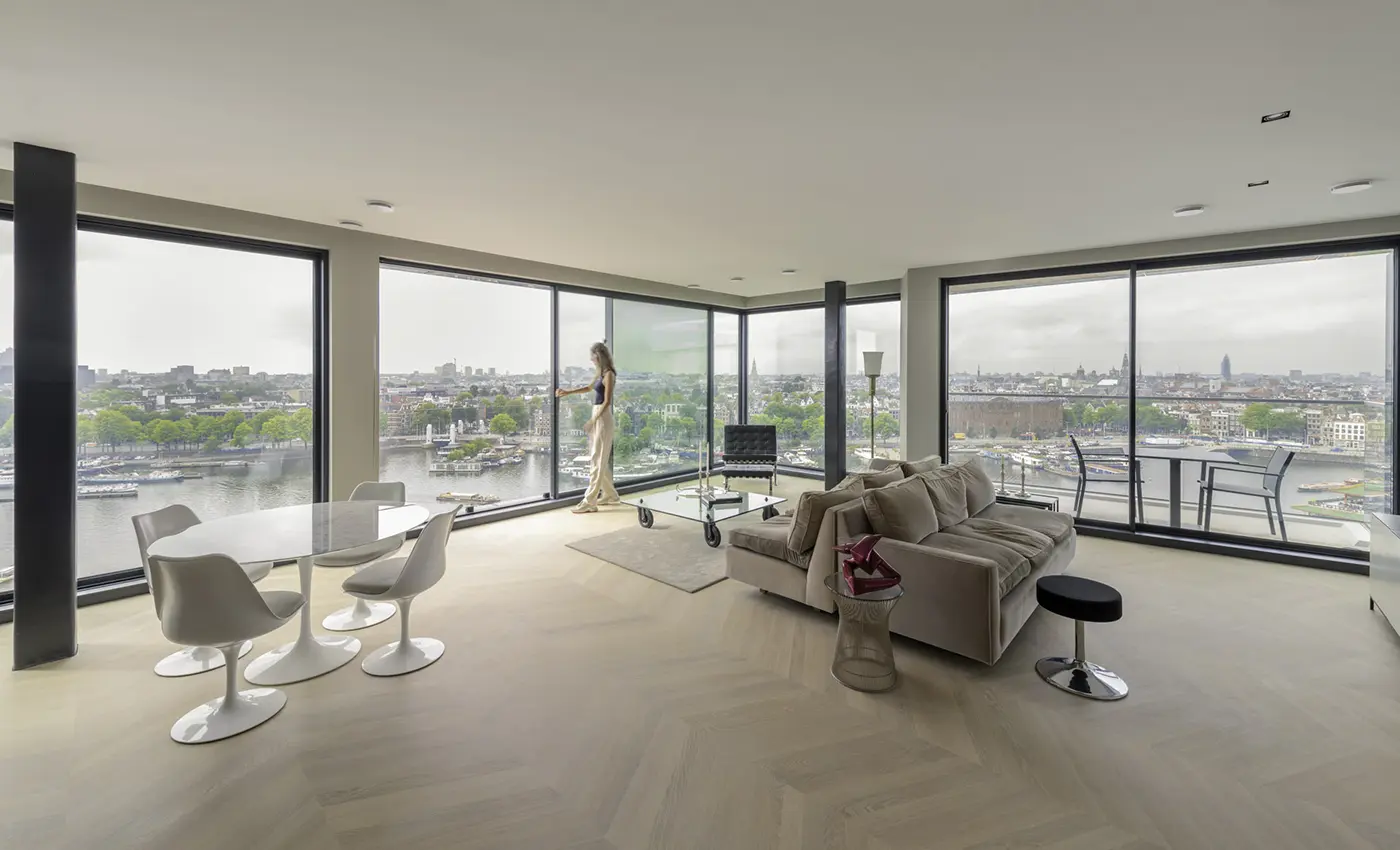 Loft mit Ausblick auf einen Hafen durch sehr große und viele Schiebefenster.