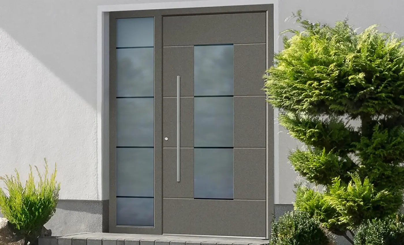 Moderne, graue Aluminium-Haustür mit einem Milchglasfenster in der Mitte uns eines im Rahmen links daneben